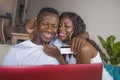 Lifestyle portrait of young happy and attractive black African American couple enjoying at home using credit card and laptop Royalty Free Stock Photo