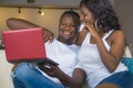 Lifestyle portrait of young happy and attractive black afro American couple enjoying at home using credit card and laptop computer Royalty Free Stock Photo