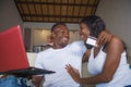 Lifestyle portrait of young happy and attractive black afro American couple enjoying at home using credit card and laptop computer Royalty Free Stock Photo