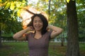 Lifestyle portrait of young happy and beautiful Asian Chinese woman relaxed and cheerful at city park playing and jumping carefree Royalty Free Stock Photo