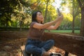 Lifestyle portrait of young happy and beautiful Asian Chinese woman taking selfie picture with mobile phone relaxed and cheerful Royalty Free Stock Photo