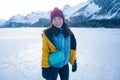 Lifestyle portrait of young happy and beautiful Asian Chinese woman in winter jacket and beanie enjoying the snow standing on