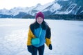 Lifestyle portrait of young happy and beautiful Asian Chinese woman in winter jacket and beanie enjoying the snow standing on