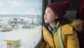 Lifestyle portrait of young happy and beautiful Asian Japanese woman in yellow jacket and hat looking through train window Royalty Free Stock Photo
