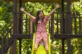 Lifestyle portrait of young happy and beautiful Asian Korean woman in sweet Summer dress playing on slide at city park smiling Royalty Free Stock Photo