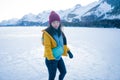 Lifestyle portrait of young happy and beautiful Asian Korean woman in winter jacket and beanie enjoying the snow standing on