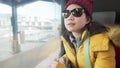 Lifestyle portrait of young happy and beautiful Asian Korean woman in yellow jacket and hat looking through train window traveling Royalty Free Stock Photo