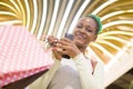 Lifestyle portrait of young happy and beautiful black African American woman holding shopping bags buying at mall fashion store