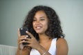 Lifestyle portrait of young happy and beautiful black african american woman at home using mobile phone networking and te Royalty Free Stock Photo