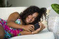 Lifestyle portrait of young happy and beautiful black african american woman networking at home using internet mobile phone textin Royalty Free Stock Photo