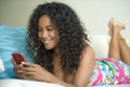 Lifestyle portrait of young happy and beautiful black african american woman networking at home using internet mobile phone textin Royalty Free Stock Photo