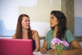 Young happy caucasian woman and beautiful hispanic girl working at office cafe with laptop computer discussing as digital business Royalty Free Stock Photo