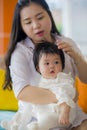 Lifestyle portrait of young happy and cute Asian Chinese woman playing and holding sweet adorable baby girl together in mother and Royalty Free Stock Photo