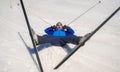 Lifestyle portrait of young happy and funny man in cross country ski lying on snow playful enjoying winter holidays on Swiss Alps Royalty Free Stock Photo