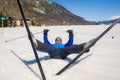 Lifestyle portrait of young happy and funny man in cross country ski lying on snow playful enjoying winter holidays on Swiss Alps Royalty Free Stock Photo