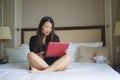 Lifestyle portrait of young happy and relaxed Asian Korean woman at hotel room bed working with laptop computer cheerful in busine Royalty Free Stock Photo