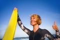 Young beautiful and happy surfer woman holding yellow surf board smiling cheerful enjoying summer holidays in tropical beach Royalty Free Stock Photo