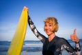 Young beautiful and happy surfer woman holding yellow surf board smiling cheerful enjoying summer holidays in tropical beach Royalty Free Stock Photo