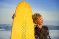 Lifestyle portrait of young beautiful and happy surfer woman holding yellow surf board smiling cheerful enjoying summer holid Royalty Free Stock Photo