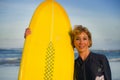 Lifestyle portrait of young beautiful and happy surfer woman holding yellow surf board smiling cheerful enjoying summer holid Royalty Free Stock Photo