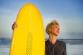 Lifestyle portrait of young beautiful and happy surfer woman holding yellow surf board smiling cheerful enjoying summer holid Royalty Free Stock Photo