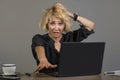 Lifestyle portrait of young stressed and messy business woman working at office laptop computer desk feeling tired and overwhelmed