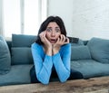 Portrait of a young woman looking scared and shocked watching TV. Human expressions and emotions Royalty Free Stock Photo