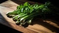 Lifestyle product photography of a fresh green onion and parsley on a wooden table. Play of light and shadow