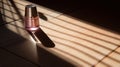 Lifestyle product shot of purple nail polish lie on wooden table. Play light and shadow
