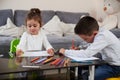 Lifestyle shot of a preschool child girl and a schoolboy sitting at the table and drawing . Indoors Royalty Free Stock Photo