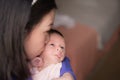 Lifestyle shot on young and happy Asian Chinese woman holding tenderly her adorable newborn baby girl in her arms in mother and Royalty Free Stock Photo