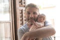 Lifestyle shot of young and happy man holding tenderly in his arms adorable newborn baby girl  in father and daughter love and Royalty Free Stock Photo