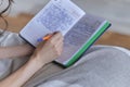 lifestyle soft image of unrecognizable young woman sitting on her cozy bed and making notes to her diary. Fall season Royalty Free Stock Photo