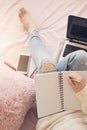 Lifestyle soft image of pretty young woman sitting in her cozy bed and making notes to her diary. Feminine workplace concept. Blog Royalty Free Stock Photo