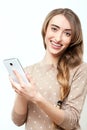 Lifestyle stylish girl using phone texting on smartphone app. Face with toothy smile. Beauty stylish blonde woman with pink lips Royalty Free Stock Photo