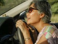 Lifestyle Summer portrait of middle aged happy and attractive classy Asian Indonesian woman driving left hand car smiling cheerful Royalty Free Stock Photo