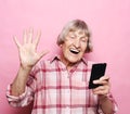 Lifestyle, tehnology and old people concept: Image of cheerful mature elderly woman with mobile phone.