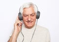 Lifestyle, tehnology and old people concept: image of an elderly gray-haired man listening to music with headphones Royalty Free Stock Photo