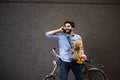 Lifestyle, transport, communication and people concept . Young man with bicycle and smartphone on city street