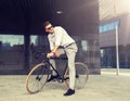 Man with bicycle and headphones on city street Royalty Free Stock Photo