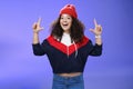 Waist-up shot of cheerful energized young woman calling friend inviting hang out as weather awesome pointing up with Royalty Free Stock Photo