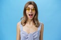 Waist-up shot of excited surprised and emotive charismatic caucasian woman in trendy sunglasses opening mouth from