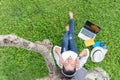 Lifestyle women enjoy listening music and reading a book and play laptop on the grass field of the nature park in the morning. Royalty Free Stock Photo