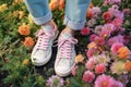 woman spring grass white fashion casual lifestyle sneakers female flowers green. Generative AI. Royalty Free Stock Photo