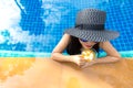 Lifestyle Woman in swimsuit relaxing and happy with cocktail on chaise-longue near swimming pool, summer day. Royalty Free Stock Photo