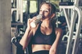 Lifestyle women drinking protein milk after exercise at the gym workout for healthy care and body slim. Fitness instructor exerc