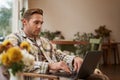 Lifestyle and workplace concept. Young handsome man in casual clothes, sitting in cafe with laptop, studying online Royalty Free Stock Photo