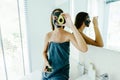 Teen girl applying black clay facial mask with avocado Royalty Free Stock Photo