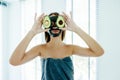 Teen girl applying black clay facial mask with avocado Royalty Free Stock Photo