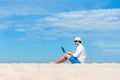 Lifestyle young asian man working on laptop while sitting chill on the beautiful beach, freelance working social on holiday summer